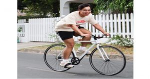 Picture of a young man in shorts and t-shirt riding a bike in the street. The role social media can play in improving sales for your business